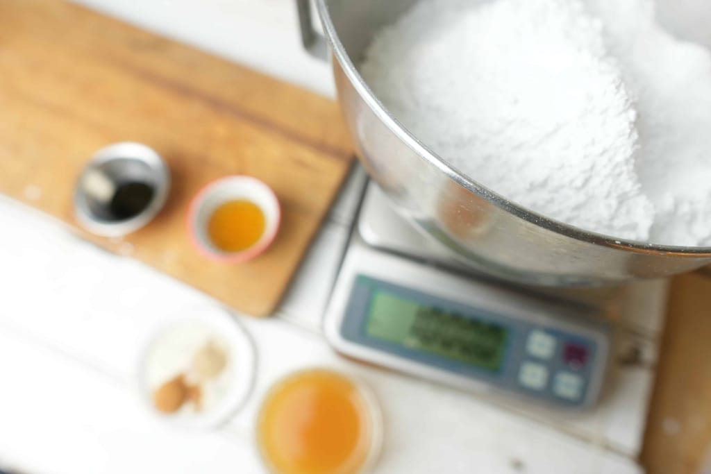 Ingredients for making the apple cider glaze, showing the powdered sugar in a bowl on a scale.