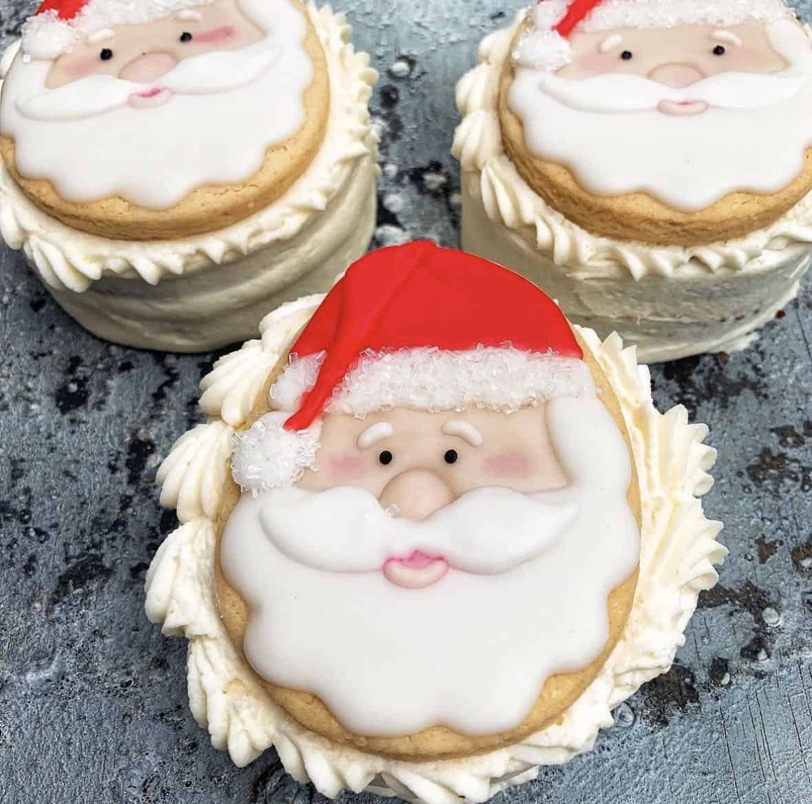 Three vegan santa claus cookies with icing on top.