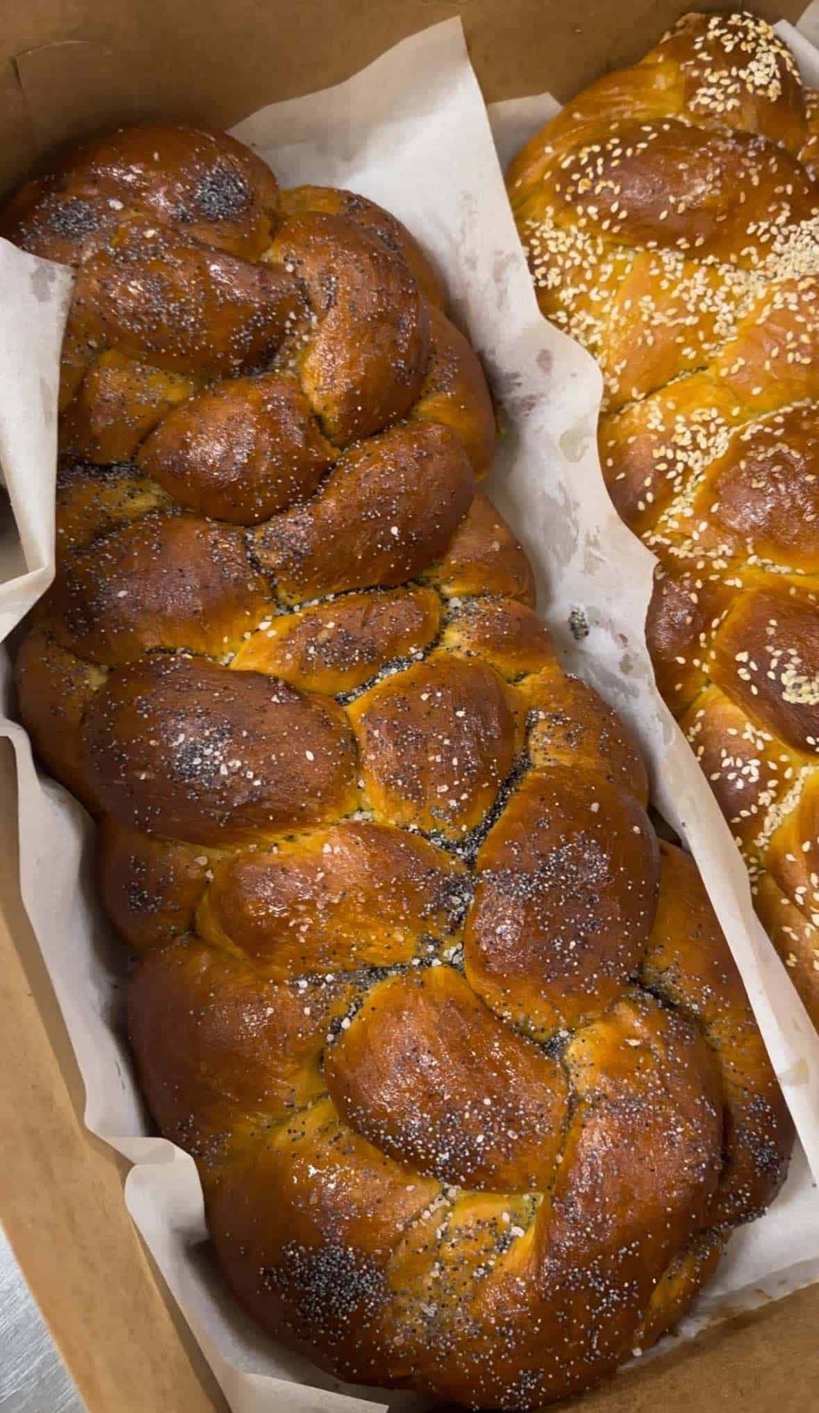 Two braided breads in a cardboard box.