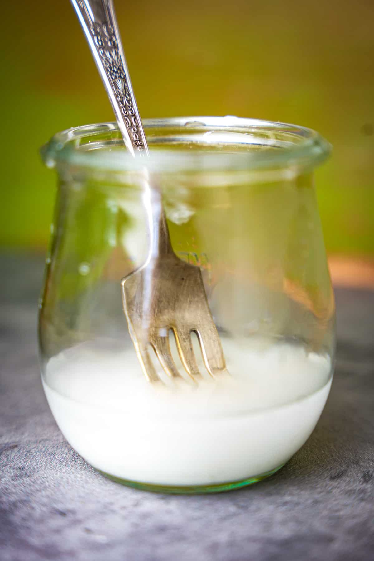 Cornstarch slurry is disolved in a small glass with a fork.
