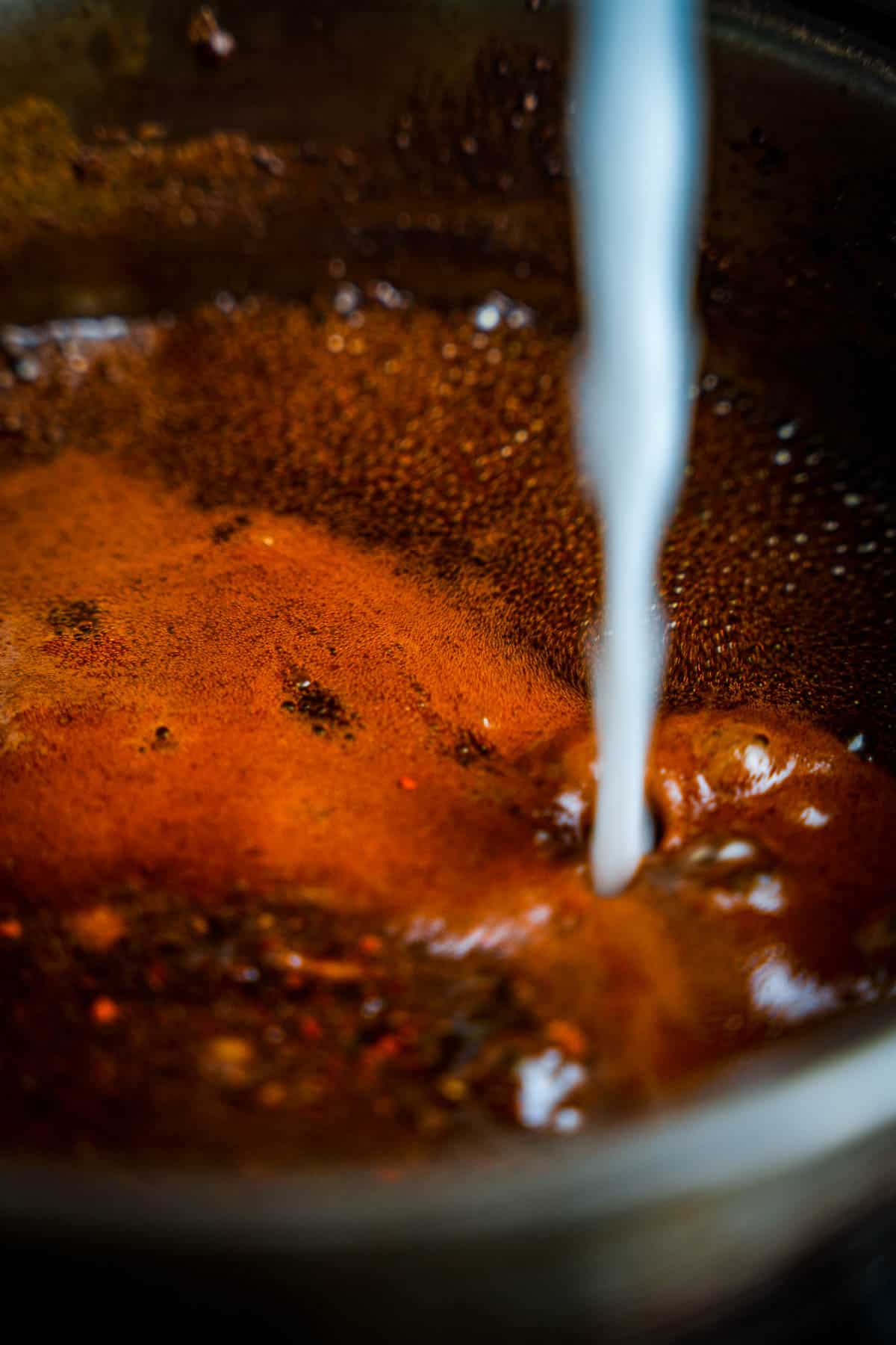 Cornstarch mixture is added to the boiling sauce.