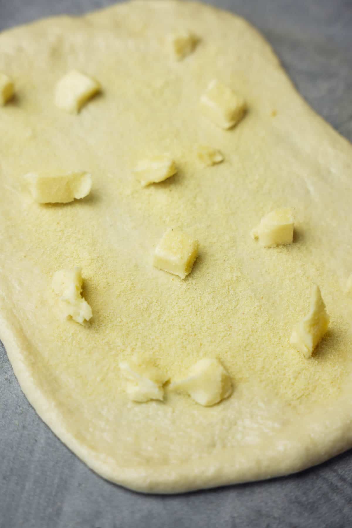 Dough rolled out and topped with butter and semolina for the first folding.