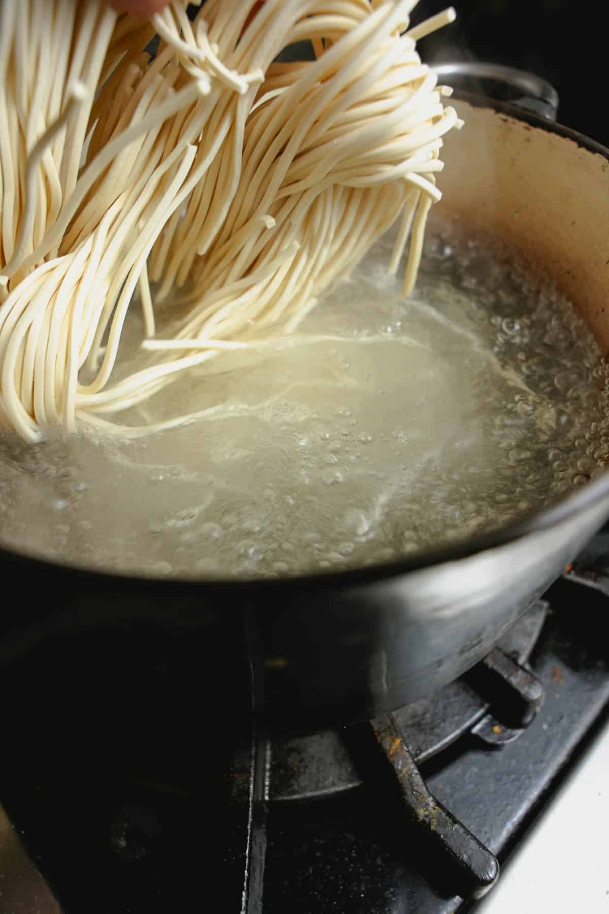 Noodles are added to boiling water to cook until al dente.