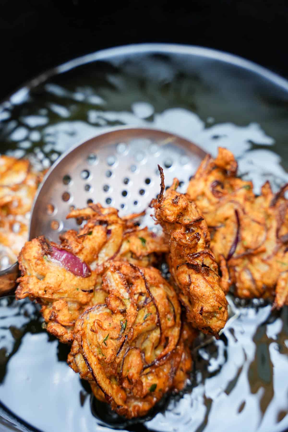 Crisp lightly golden brown bhaji are removed from the hot oil with a metal spider.