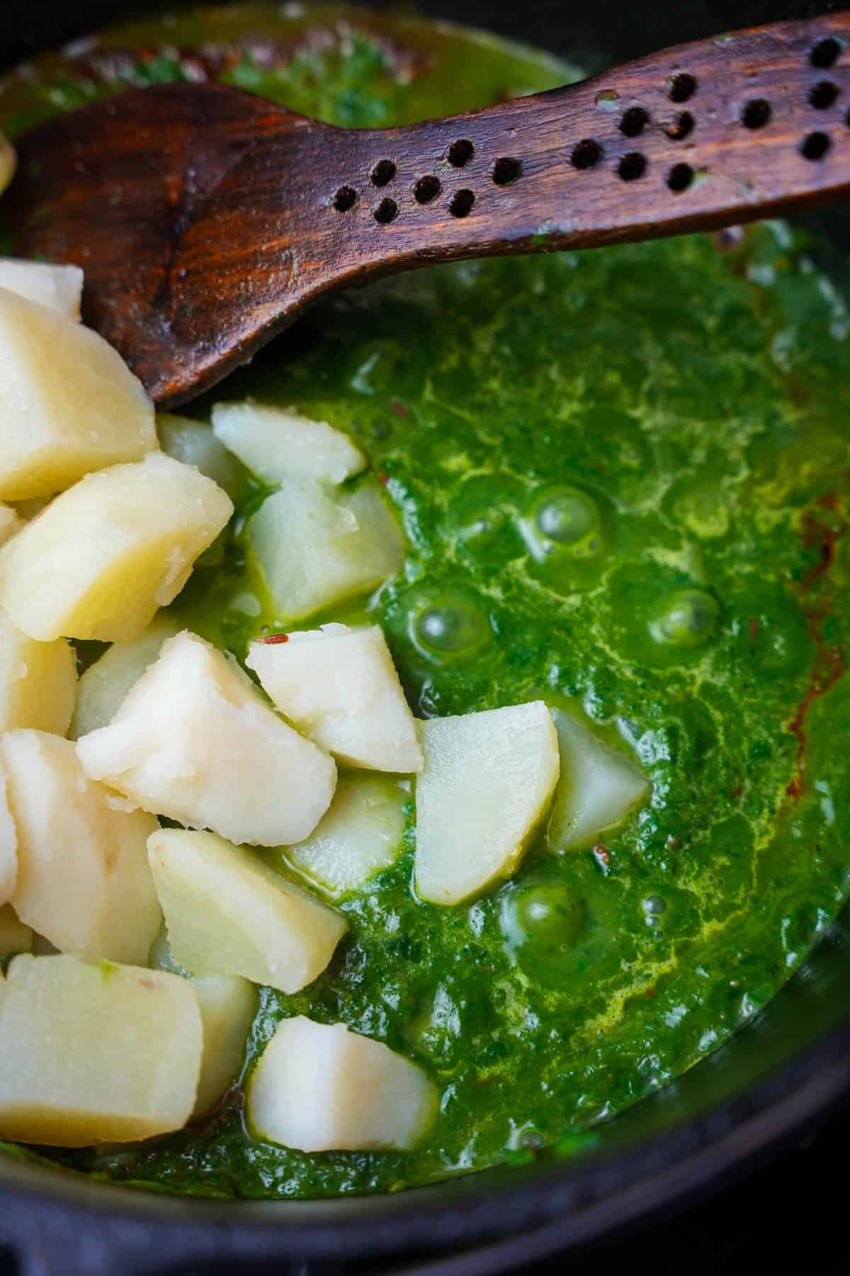 potatoes are mixed into the bubbling spinach puree.