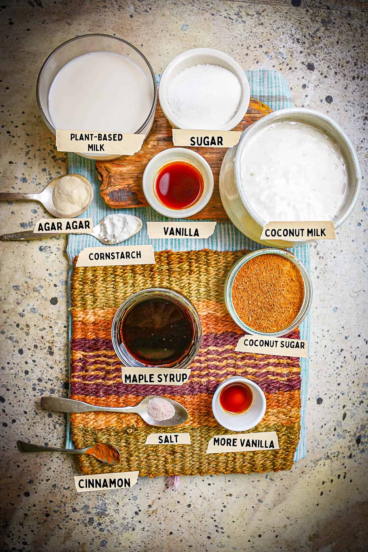 Ingredients for banh flan are measured out and labeled on top of a woven mat.