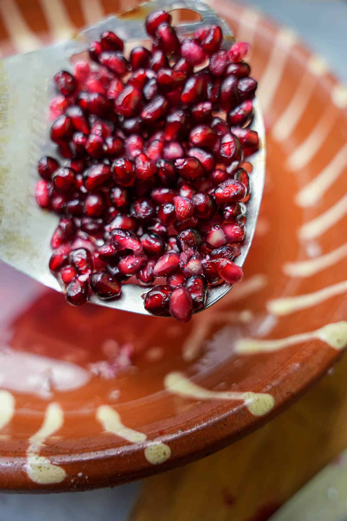 pomegranate seeds, completely free of pith and other matter are removed from the bowl of water with a slotted spoon.