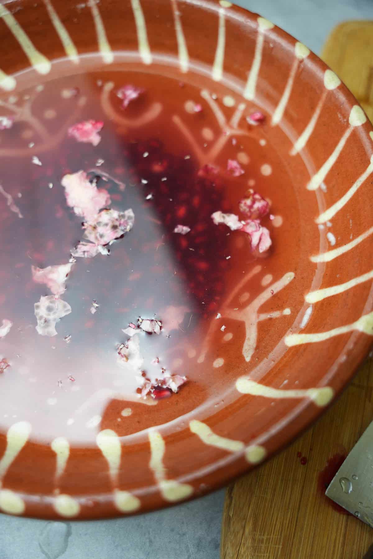 The pomegranate seeds are sperated from the flesh of the pomegranate in a bowl of water. the seeds sink and the pith rises to the surface to be discarded.