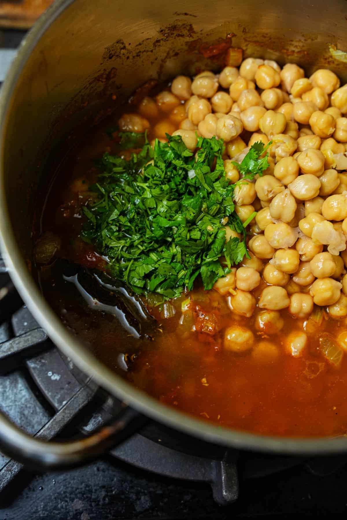 Cilantro water and chickpeas are added to the pot.
