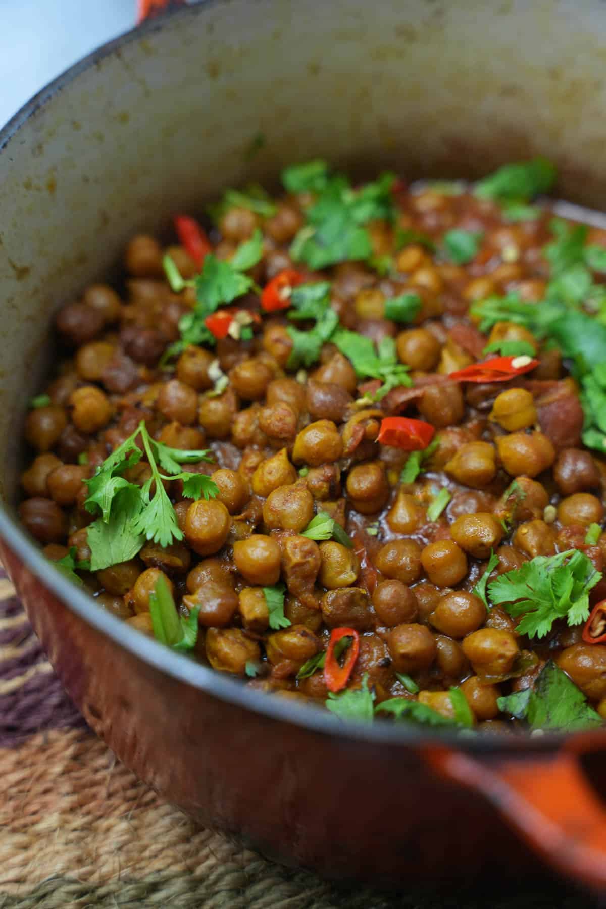 chana dal in a pot garnished with cilantro and sliced red chilies.