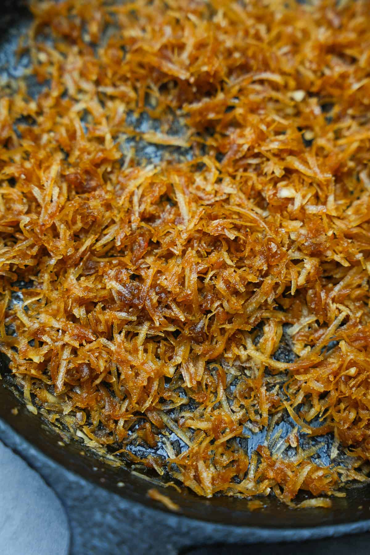 Coconut filling is cooked in a black cast iron skillet.