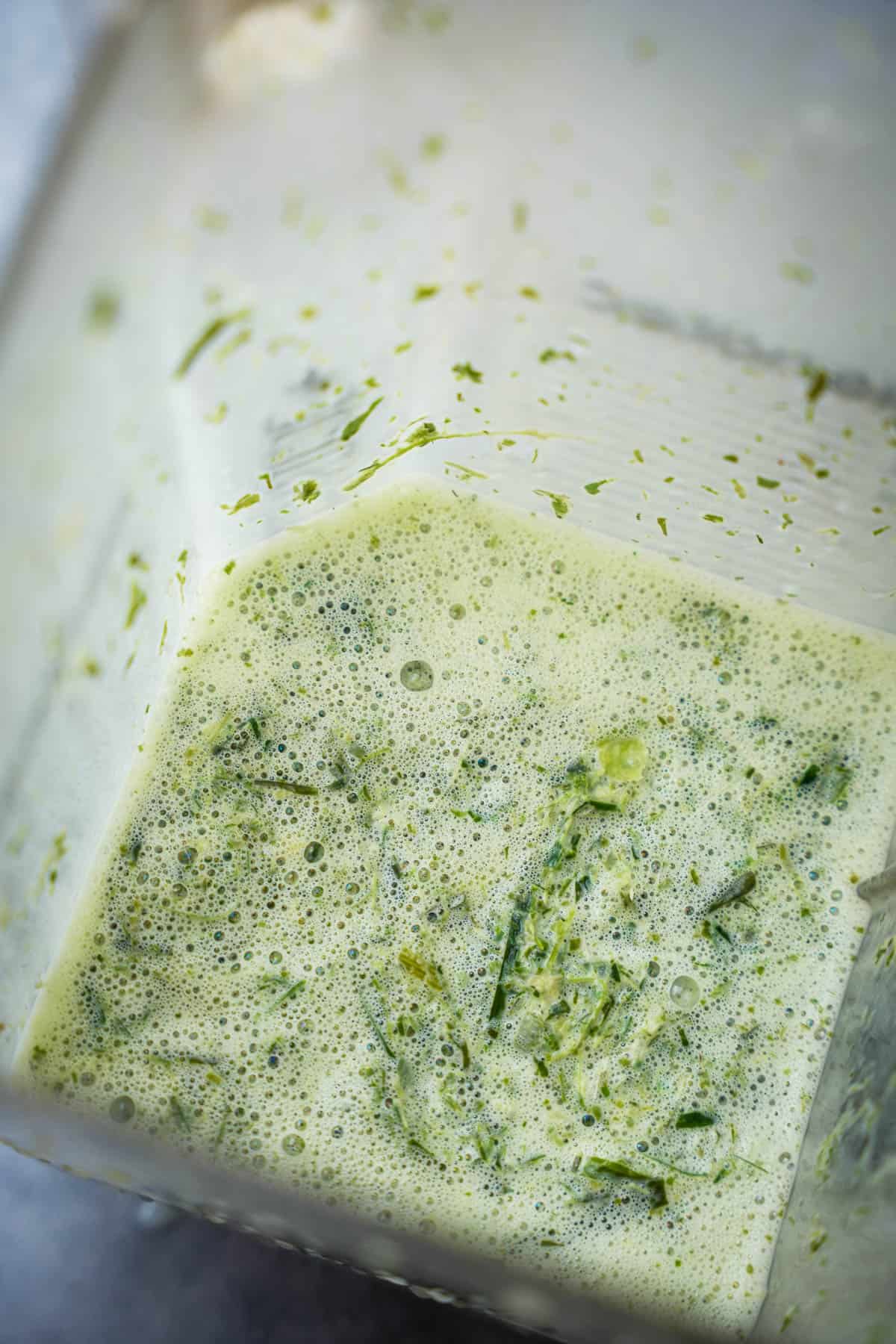 pandan and coconut milk are pureed together in a blender pitcher.