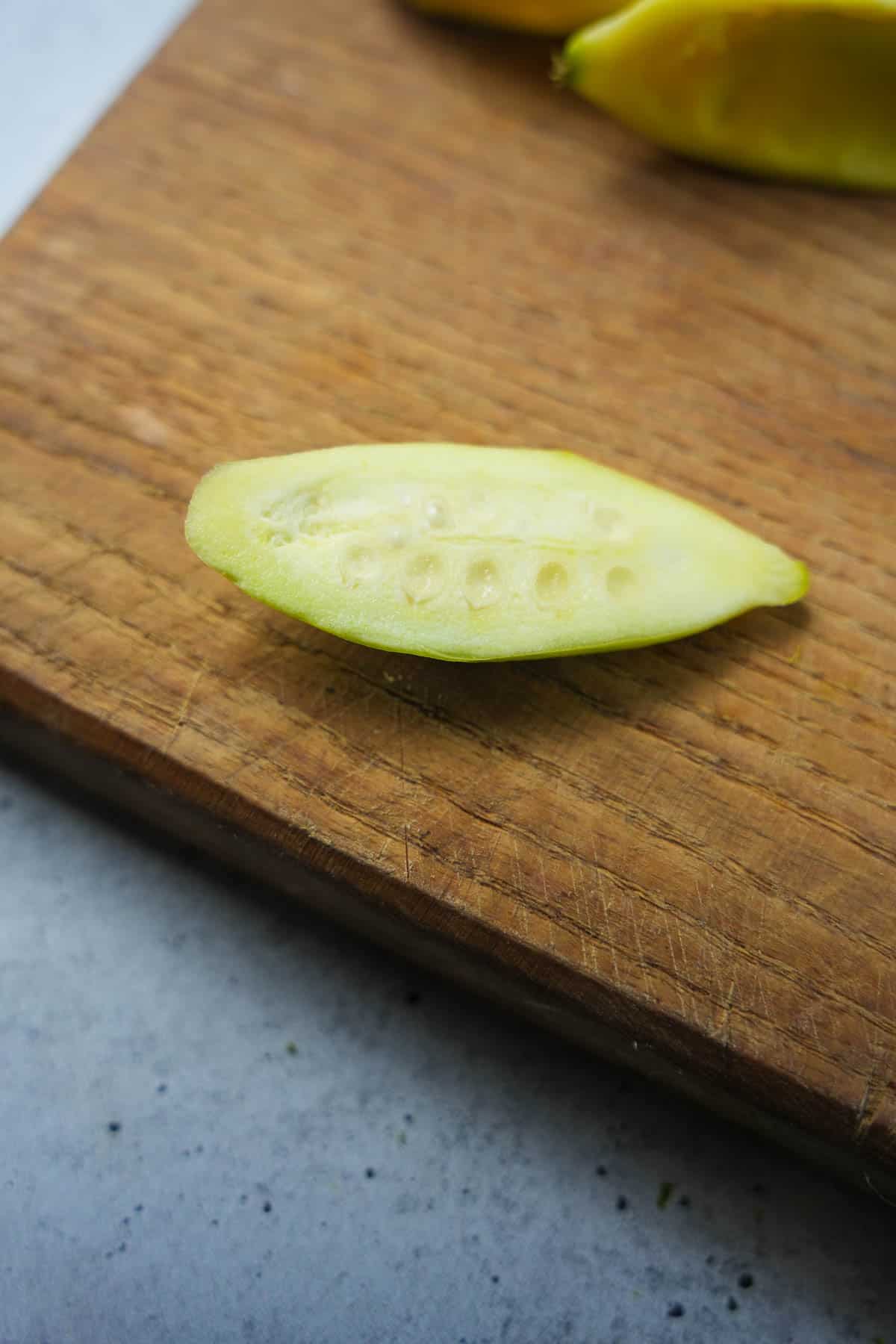 A young parwal with undeveloped seeds that don't need to be removed on a cutting board.