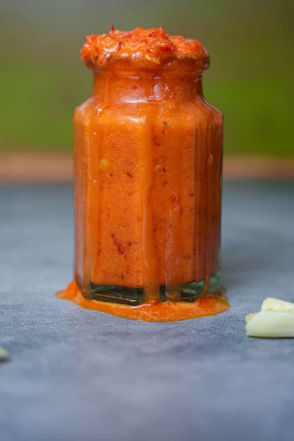 a jar of red shatta sauce with garlic on it.
