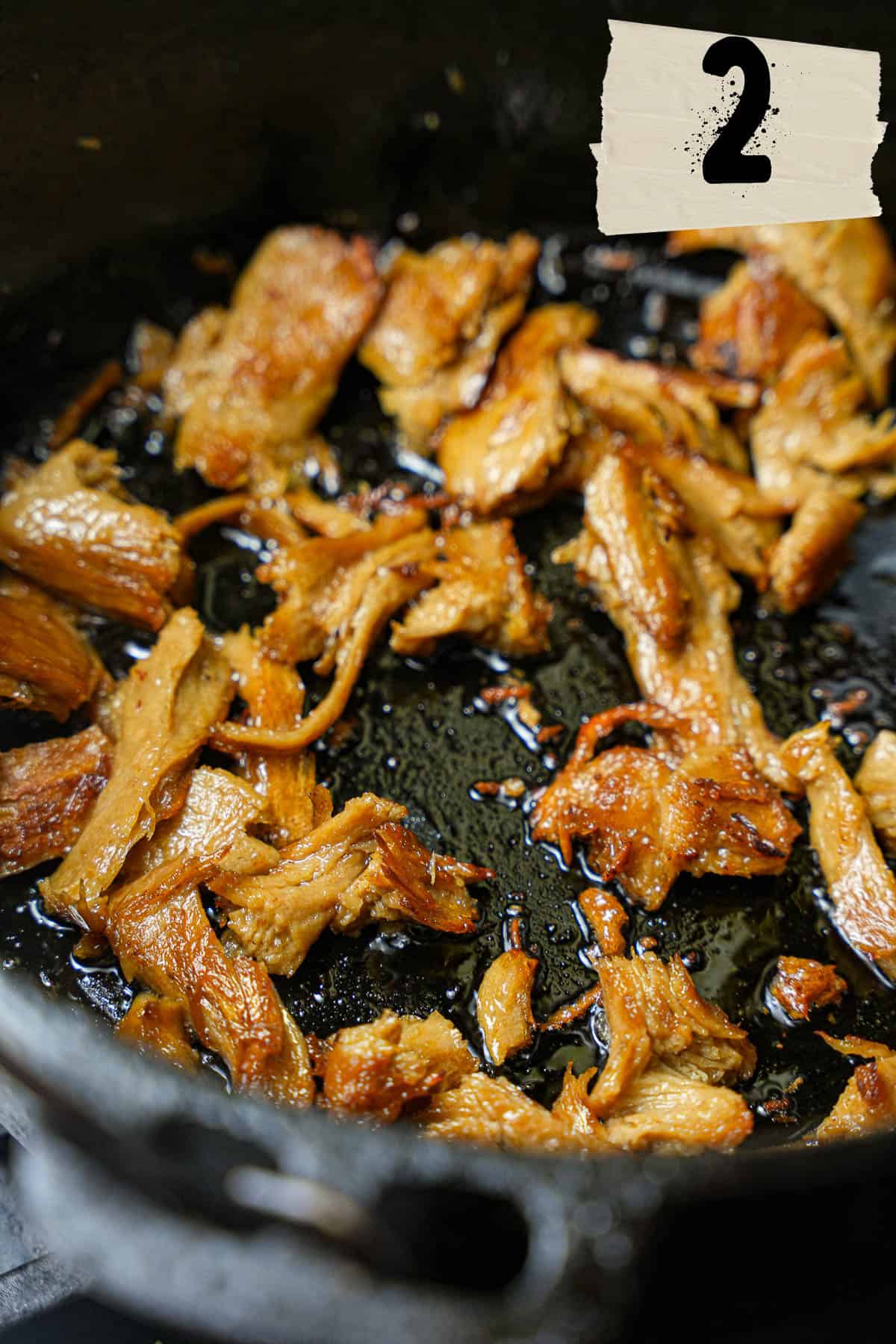 A frying pan with seitan sautéing in it.
