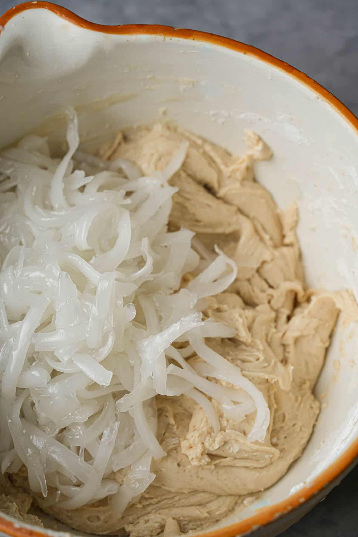 A bowl filled with coconut threads and sweet rice batter.
