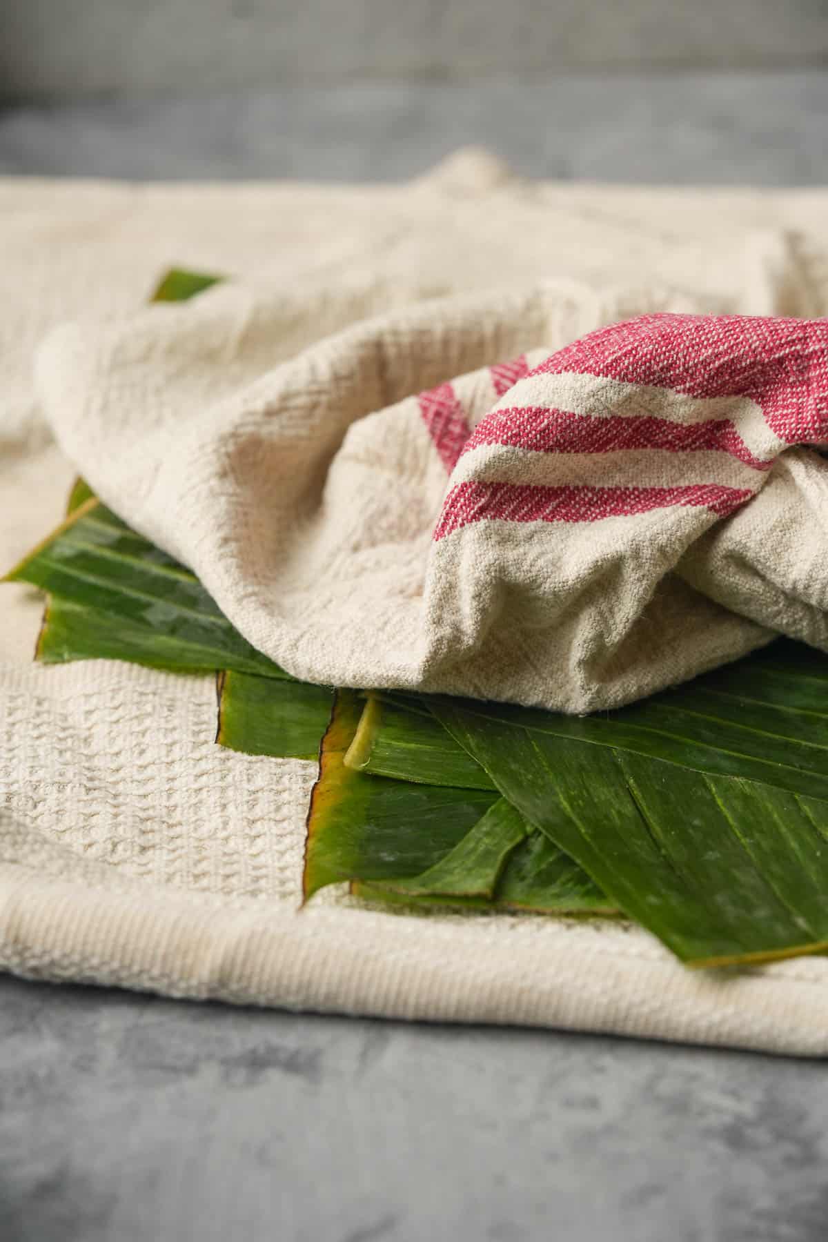 A towel with banana leaves drying on it.