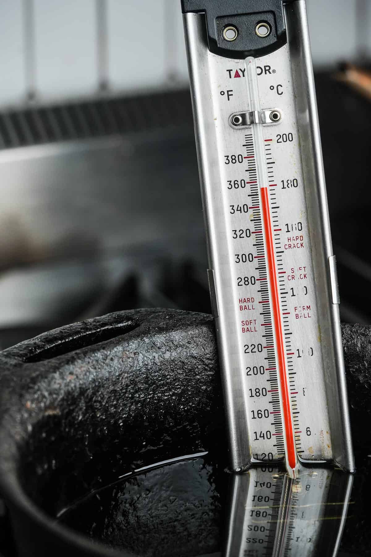 A thermometer is placed in a frying pan showing 352 degrees.