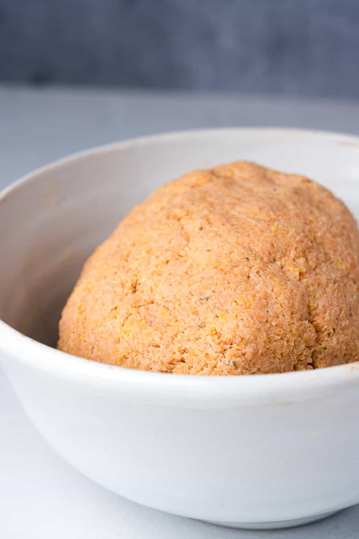 A ball of fellah kofte dough in a white bowl.