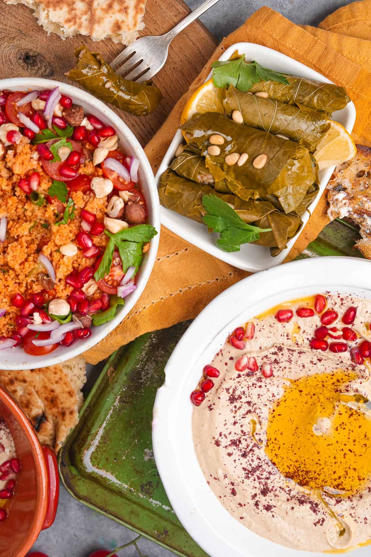 A variety of dishes with mutabal, pita bread, stuffed grape leaves, and kisir.
