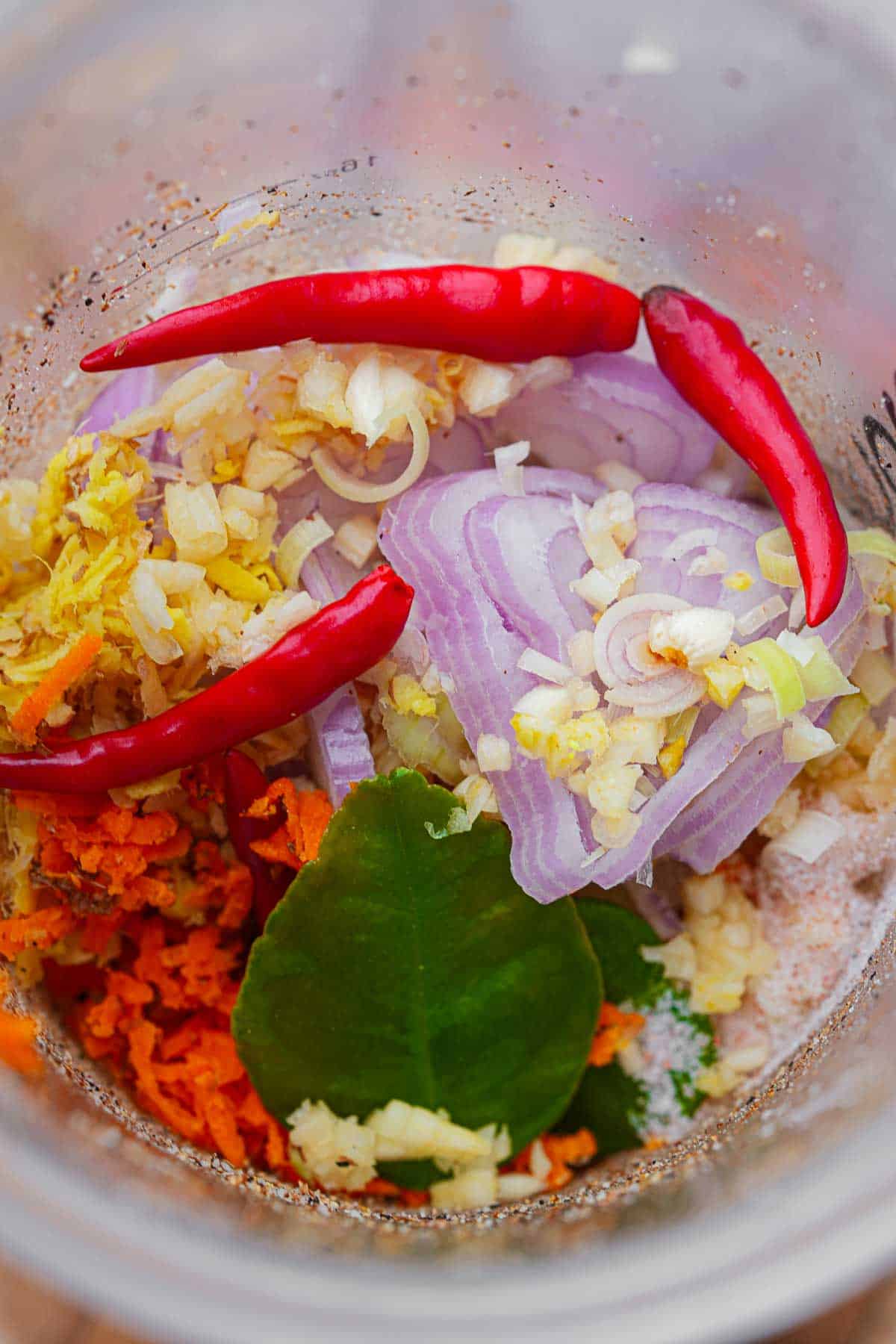 A blender filled with vegetables and spices.