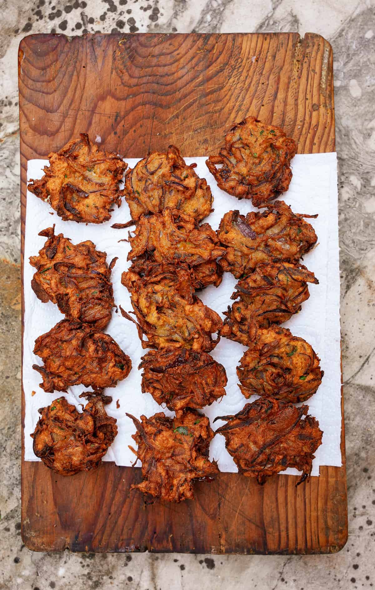 Bhaji cool on a paper-lined wooden board. the paper towels wick off excess oil.