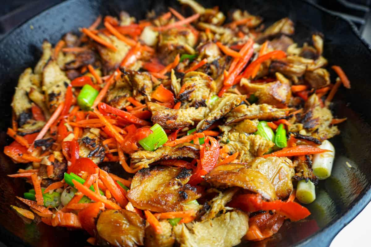 A skillet with seitan and all the veggies used in this dish being stir fried together.