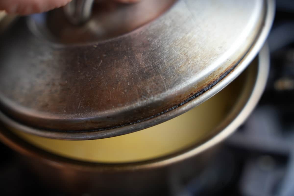A lid is put onto the pot with rice.