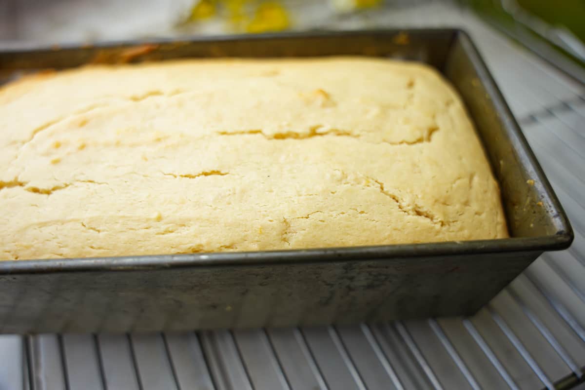 Vegan pound cake setting up and cooling in a loaf pan.