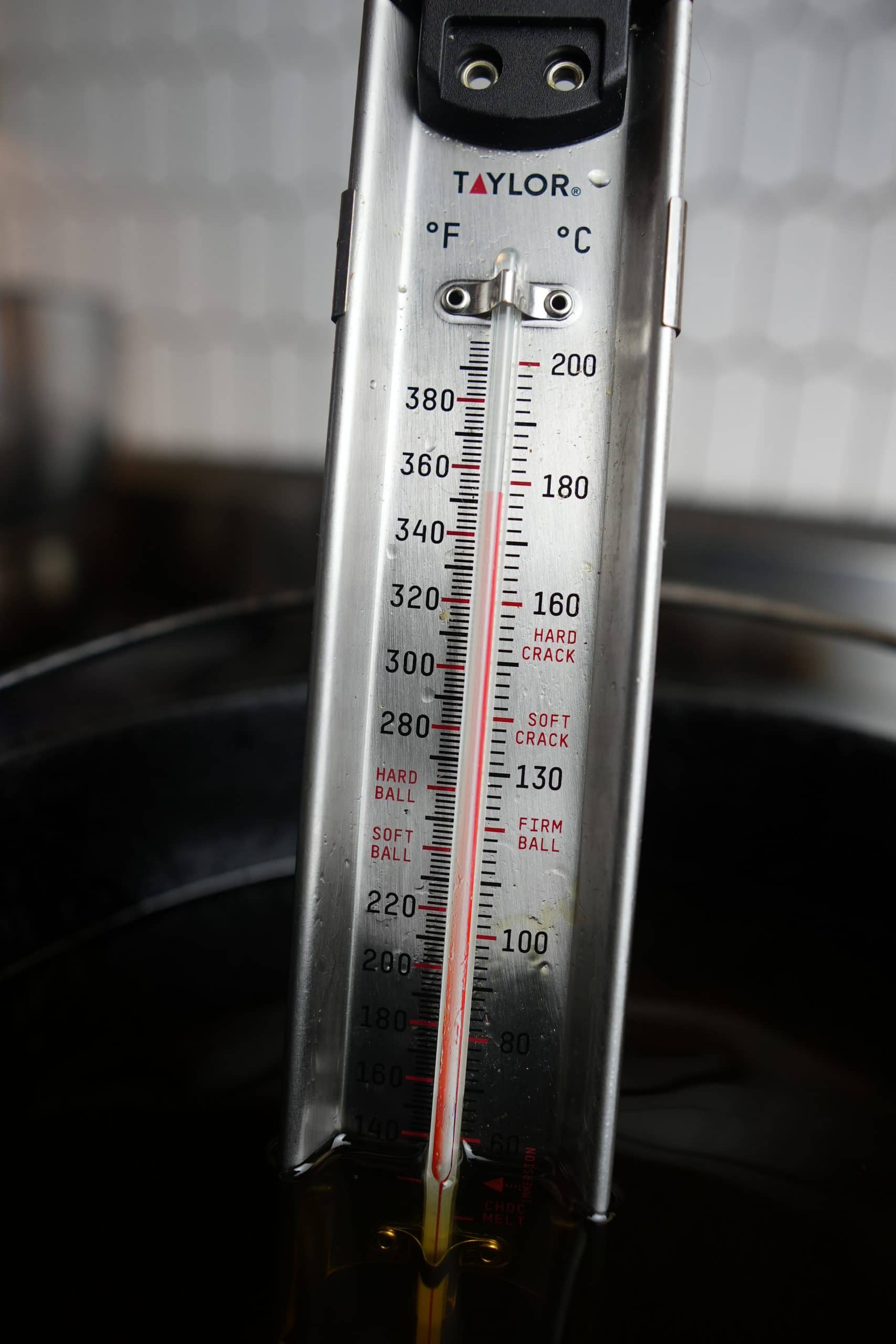A candy thermometer in a pot of hot oil reading 350 degrees.