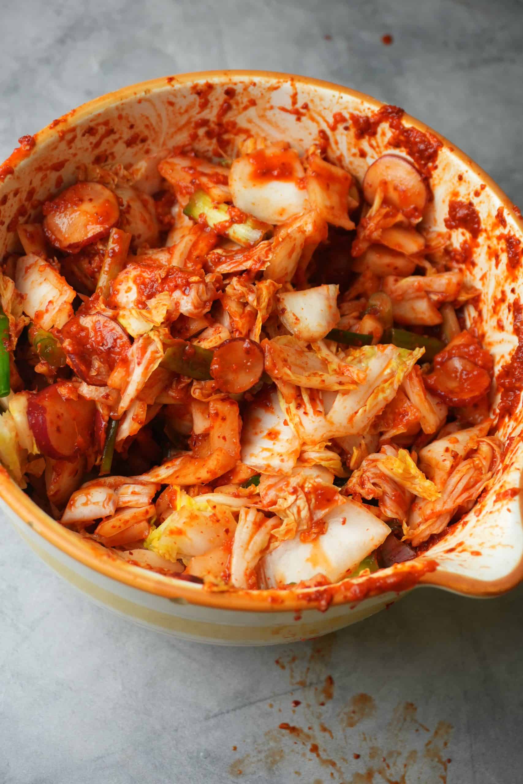 Mixed kimchi ina colorful bowl awaiting fermentation