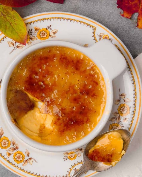 A vegan bowl of vegan crème brulee with a spoon.