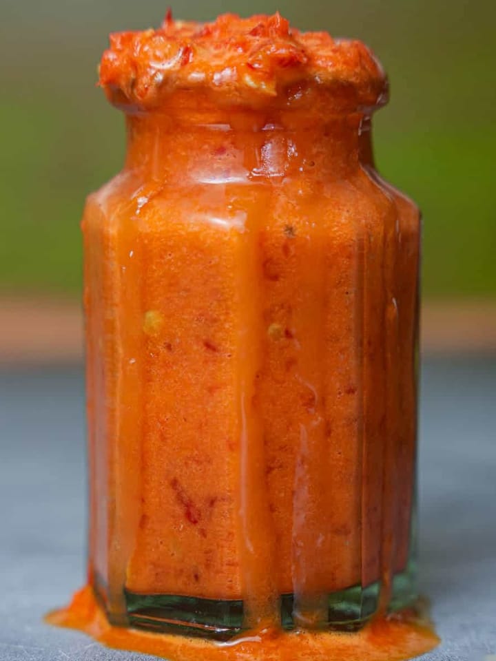 a glass jar with red shatta sauce on it.