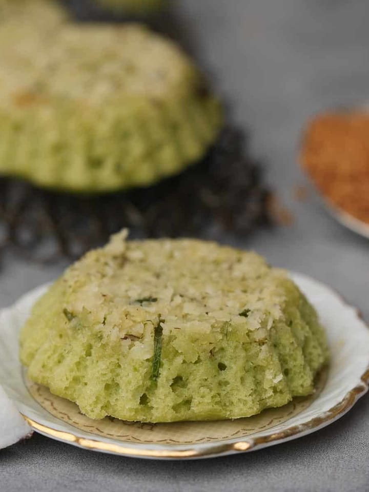 A plate with a green coconut cake on it.