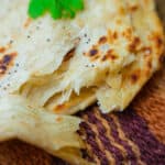 flaky malabar parotta on a woven mat
