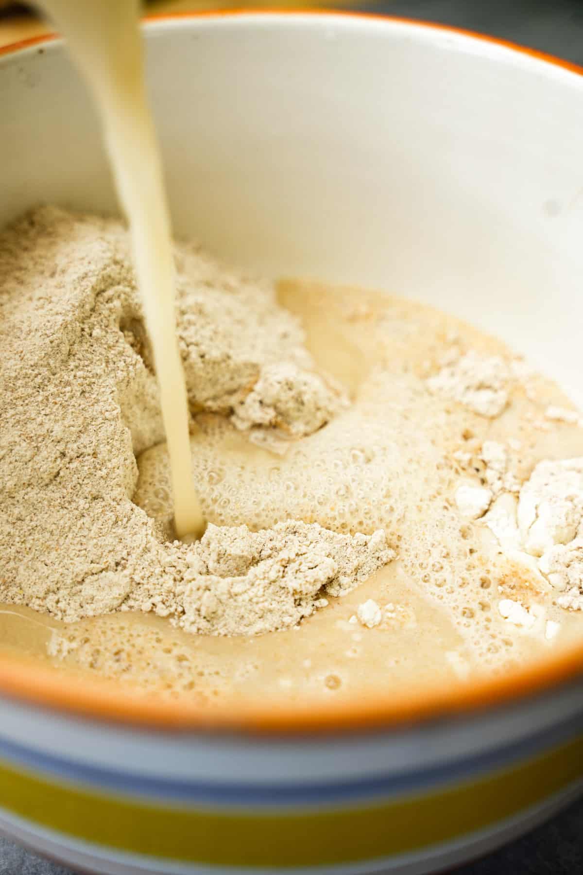 bloomed yeast mixture is added to form a dough in a ceramic bowl.