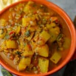lauki ki sabji being served in an orange ceramic bowl.