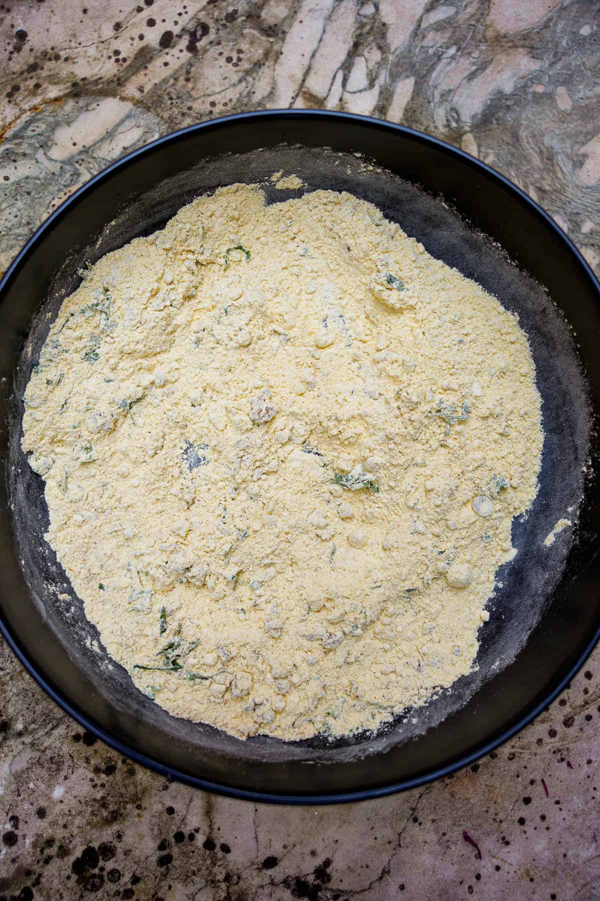 The dry ingredients are fully mixed up in a bowl awaiting the sliced onions and water.