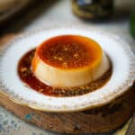 A cinnamon dusted serving of banh flan on a plate.