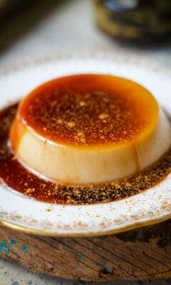 A cinnamon dusted serving of banh flan on a plate.