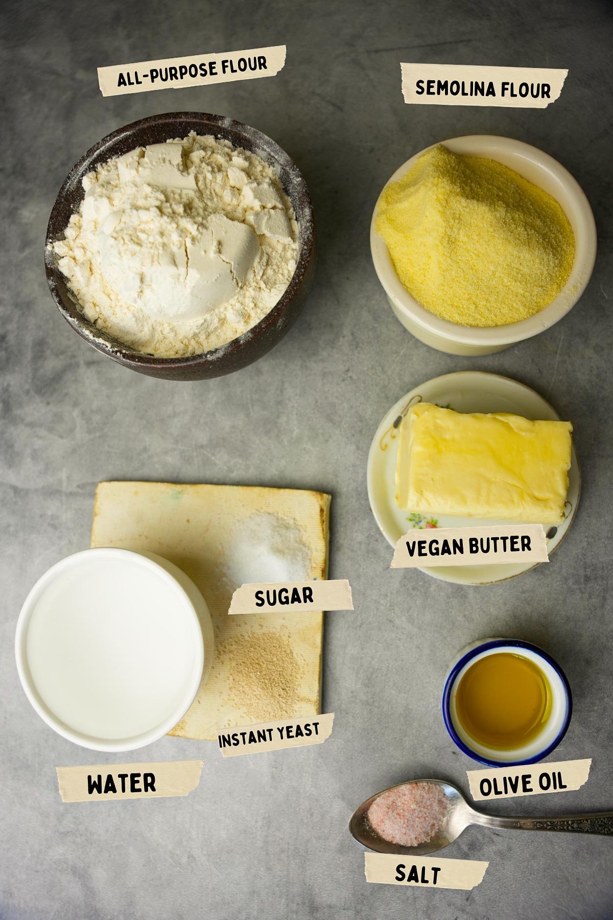 Ingredients on a table include bowls of all-purpose flour, semolina flour, vegan butter, water, sugar, instant yeast, olive oil, and salt—all essentials for making traditional msemen.