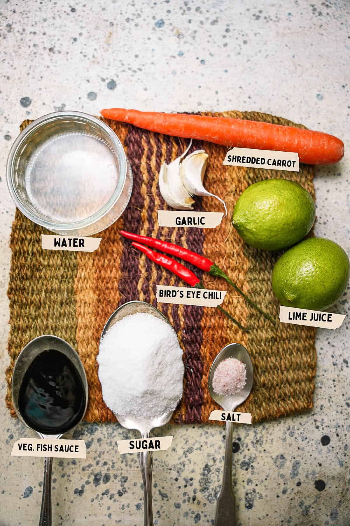 Ingredients for nuoc mam are laid on and labeled on a woven mat.