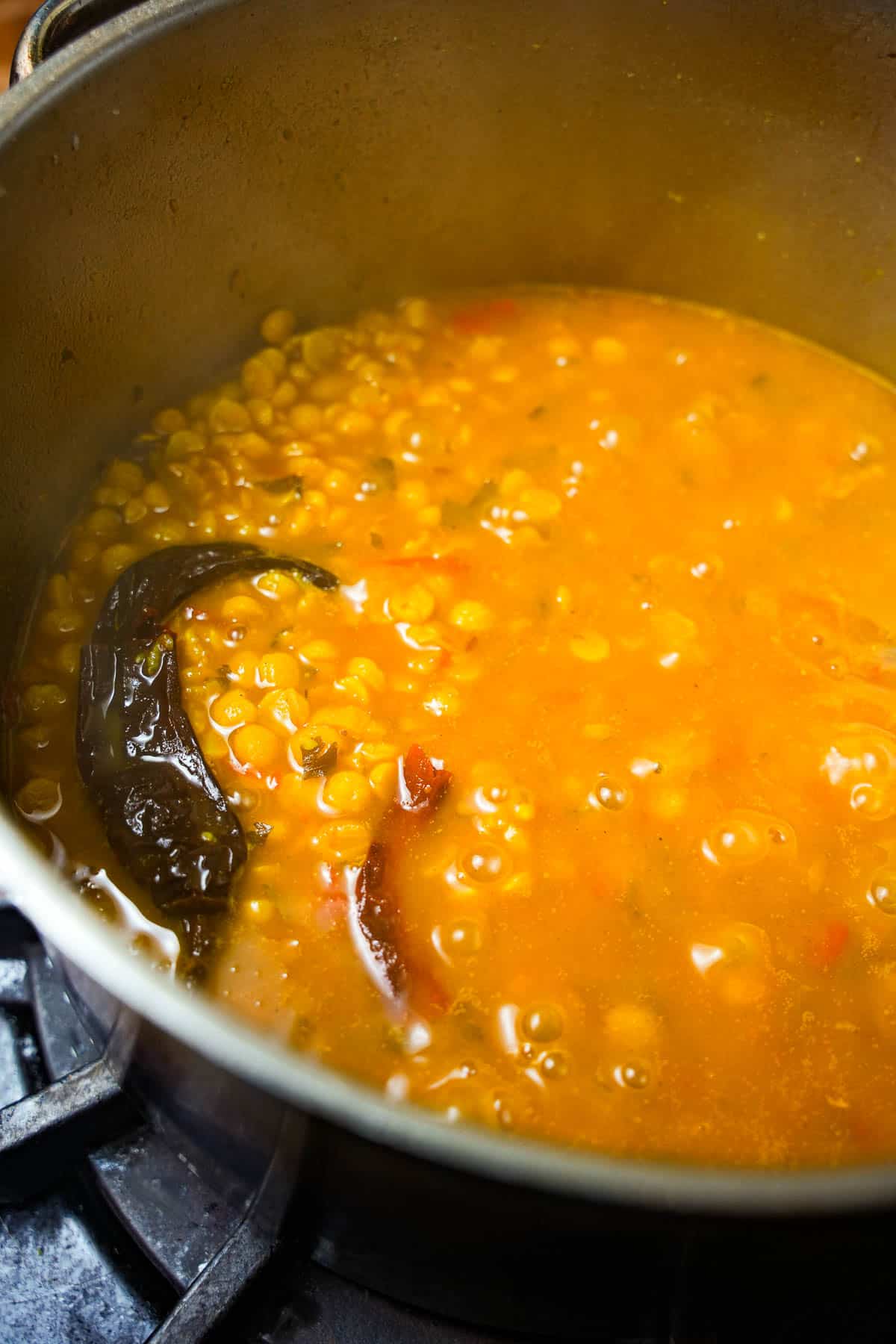 a pot of watery chana dal cooking on a stove.