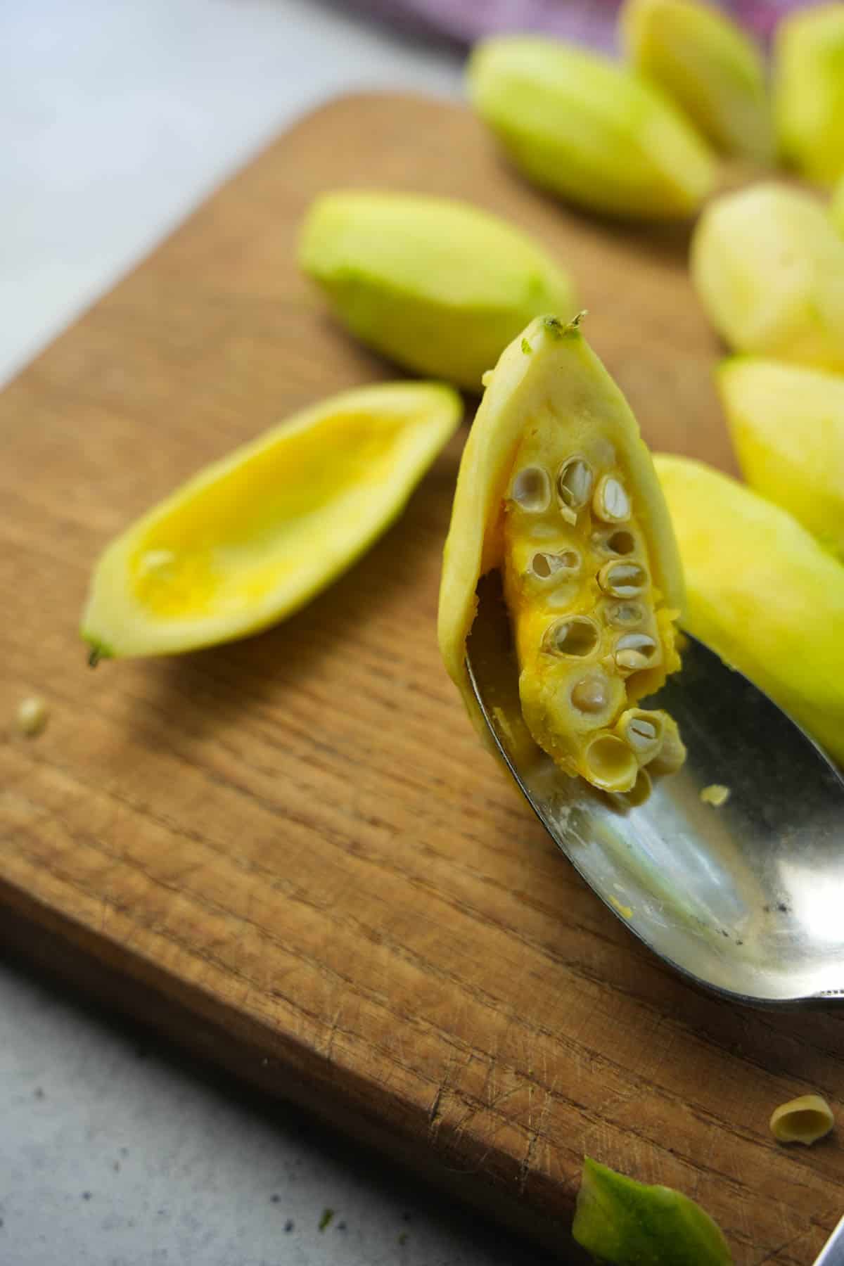 A spoon removing the seeds from the inside of mature parwal.