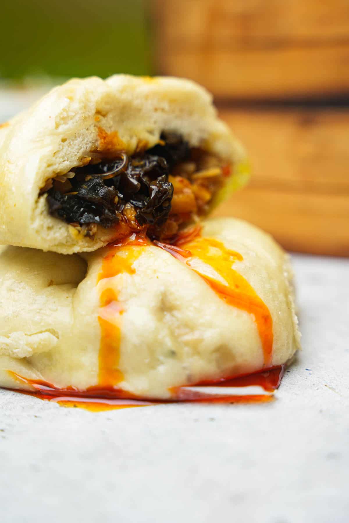 Banh bao cut into dripping with chili oil.
