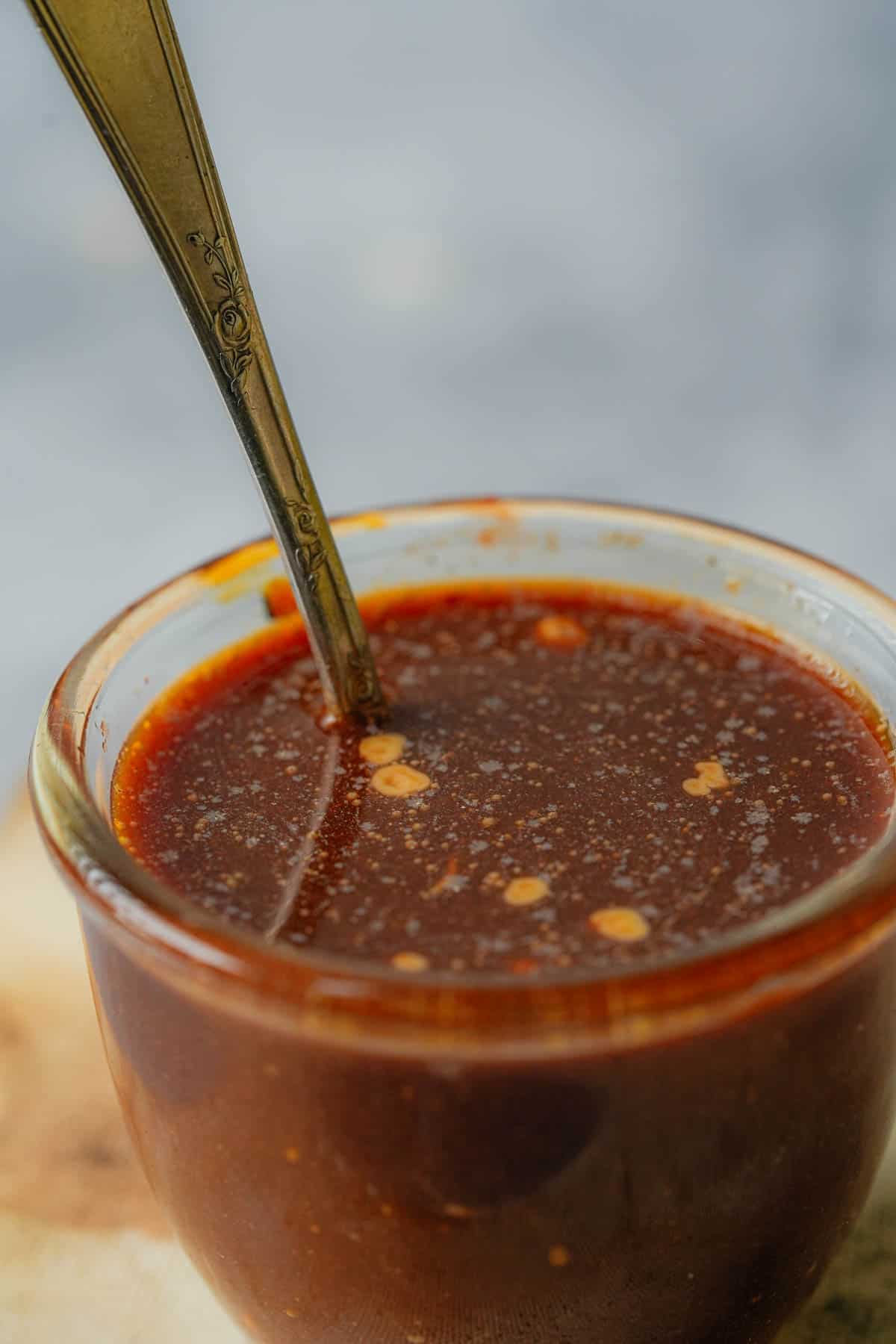 A bowl of sauce with a fork in it.