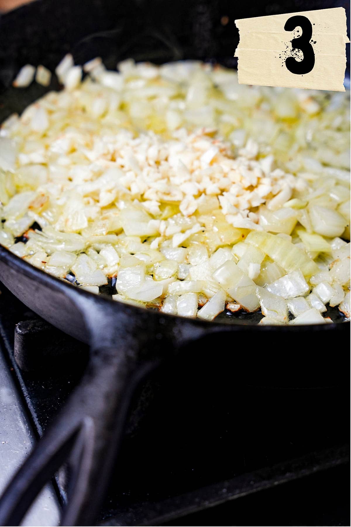 Onions and garlic sauté in a cast iron skillet.