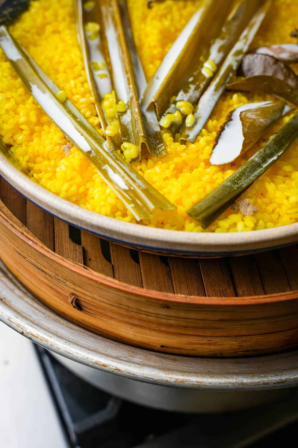 coconut milk is drizzled into the steaming rice.