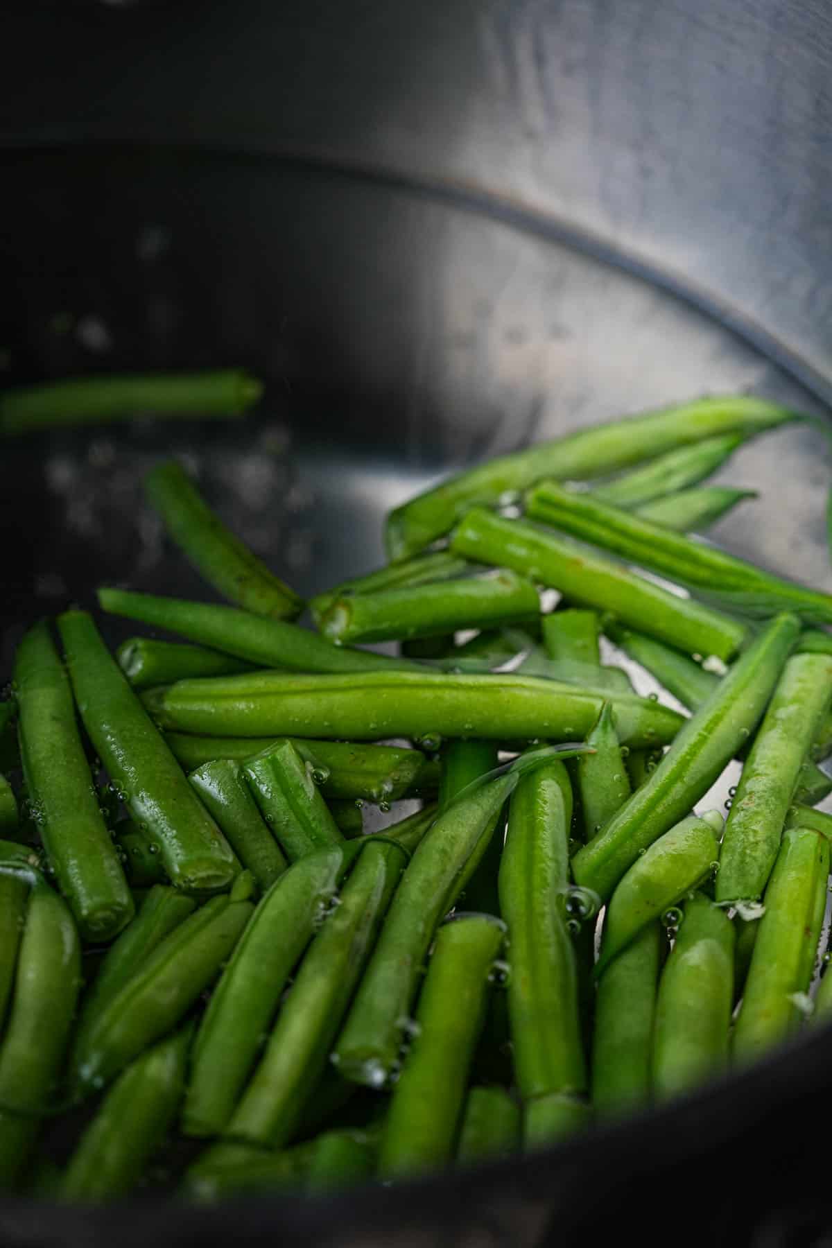 Green beans being blanched in a pot of water.