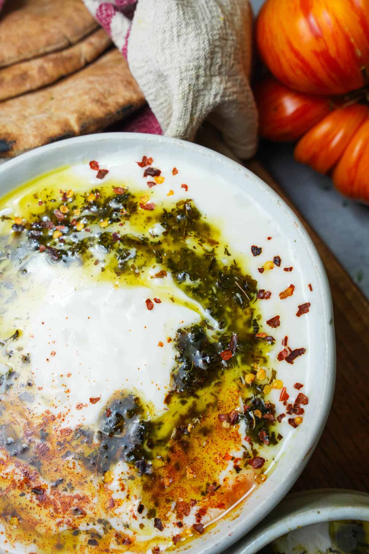 Yalya corbasi on a wooden board with pita bread..